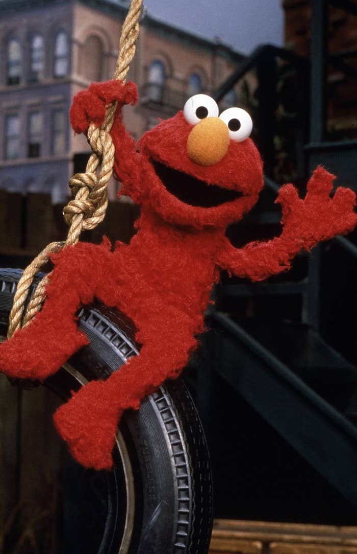 Closeup of Elmo swinging on a tire