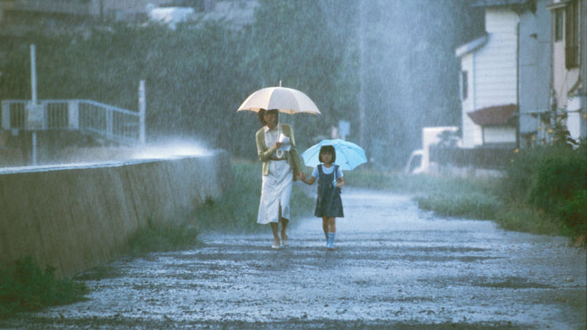 Hitomi Kuroki and Rio Kanno holding hands in the rain.