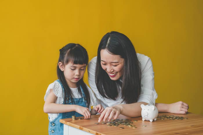 mom and daughter counting coins from a piggy bank