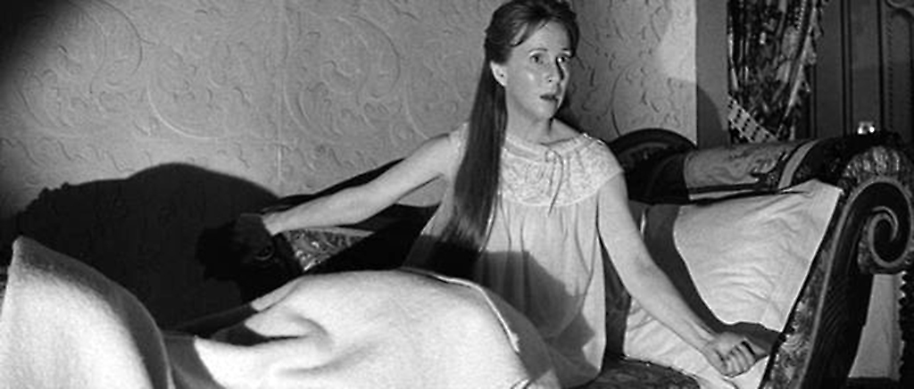 Julie Harris sitting on a chaise lounge.