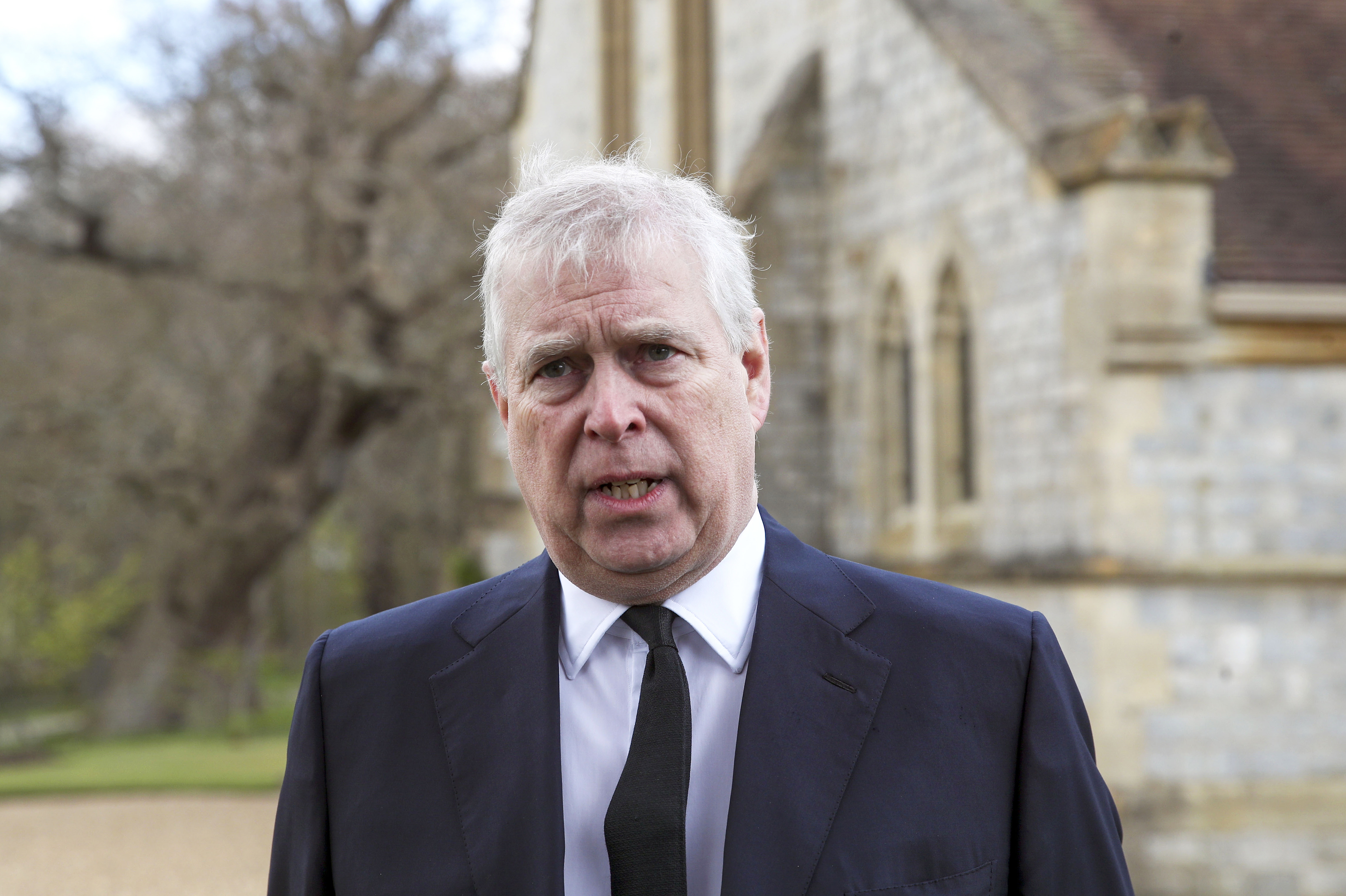 closeup of prince andrew with white hair wearing a suit