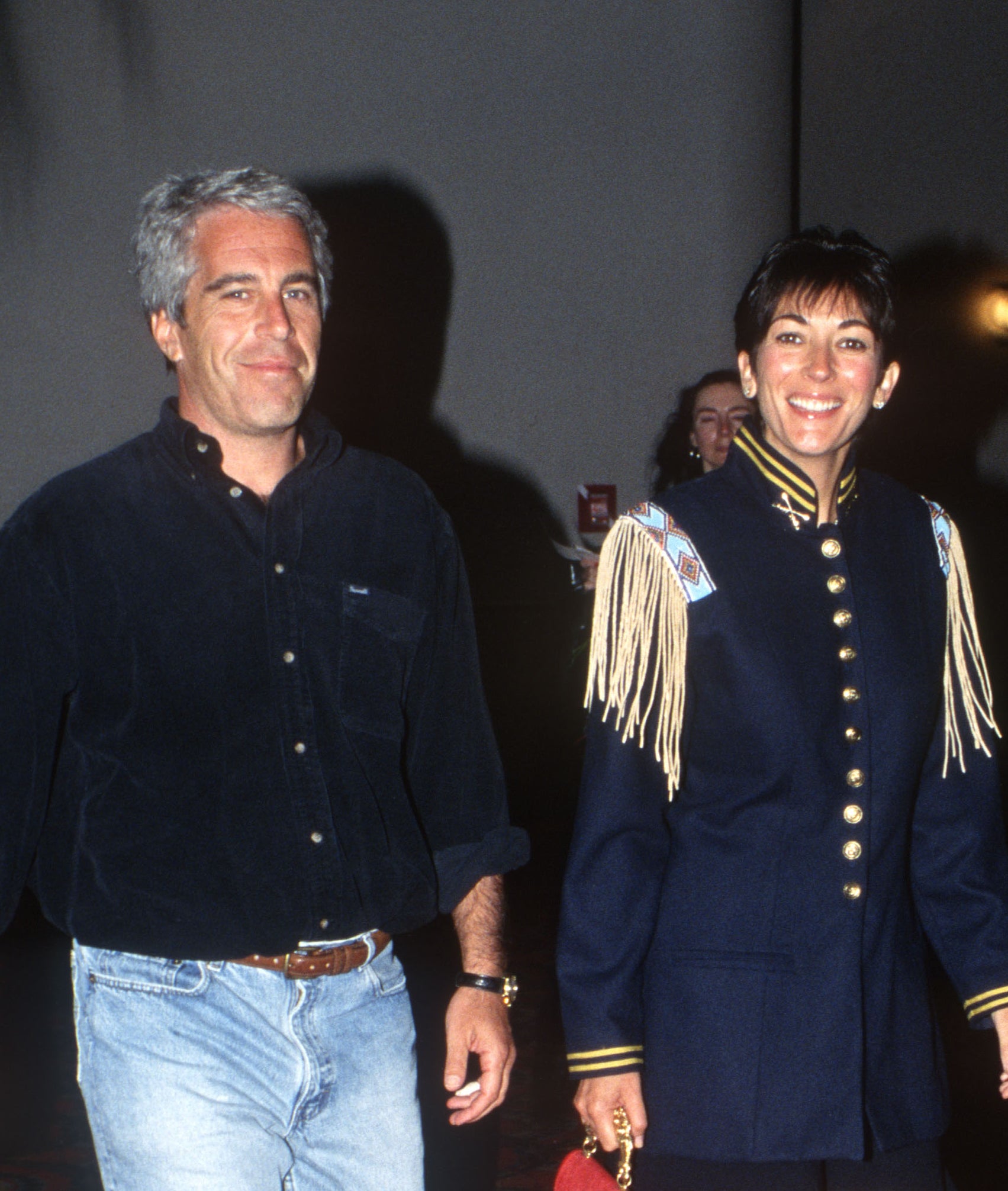 Ghislaine Maxwell smiles as she walks next to Epstein