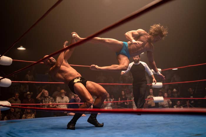 wrestler jumps up to kick another in the ring