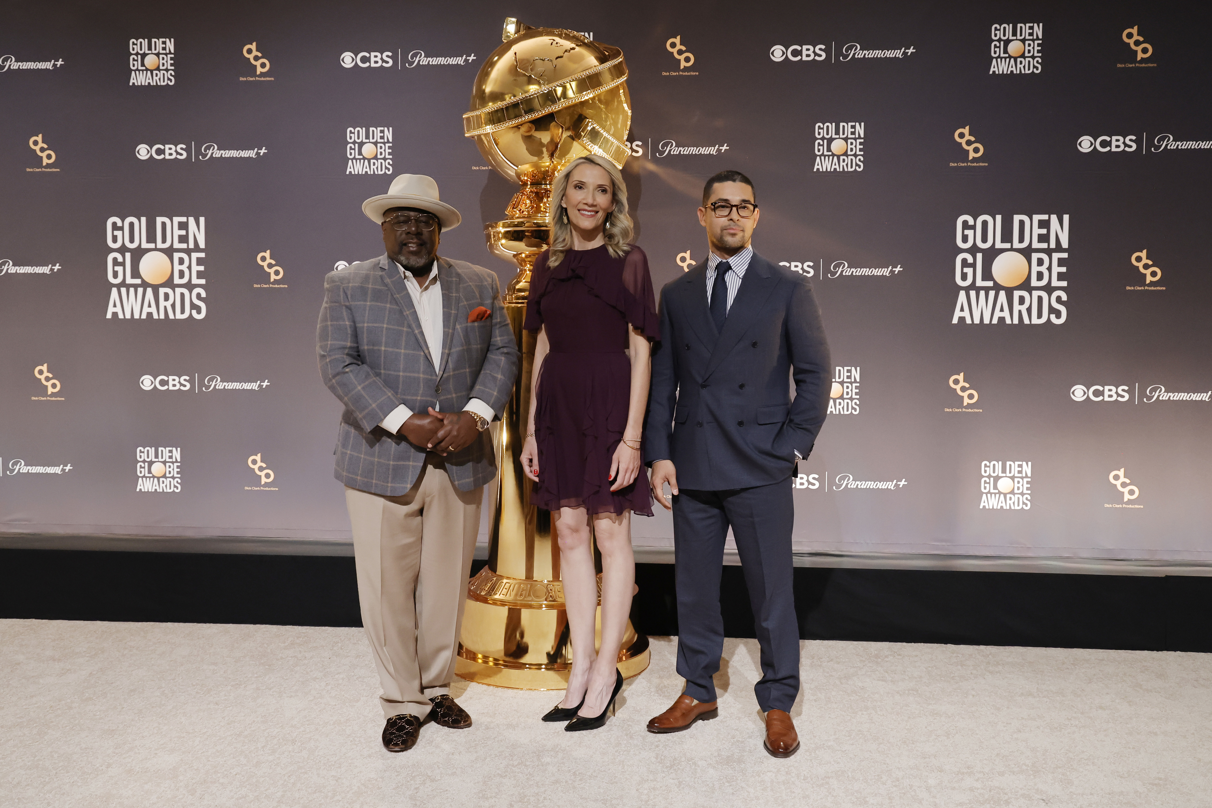 People standing in front of a Golden Globe statuette