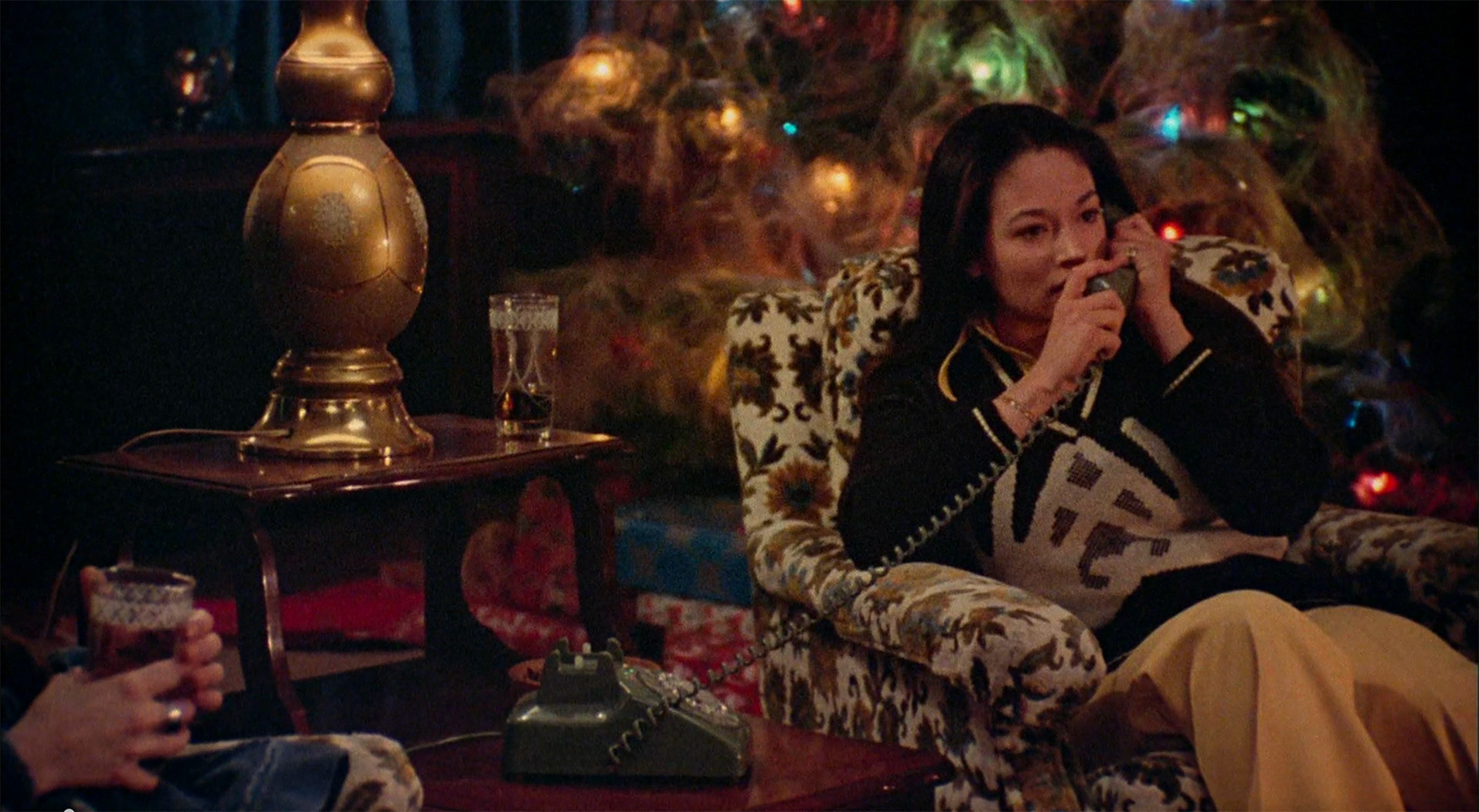 Olivia Hussey answering the phone in front of a Christmas tree.