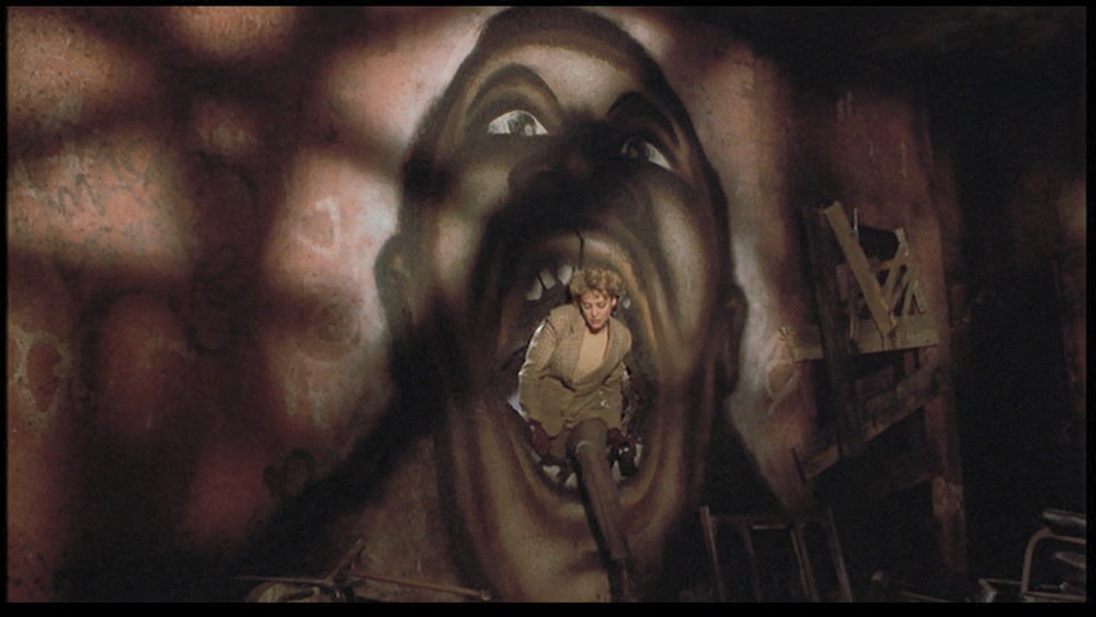 Virginia Madsen emerging from the mouth of a painting of Tony Todd&#x27;s face.