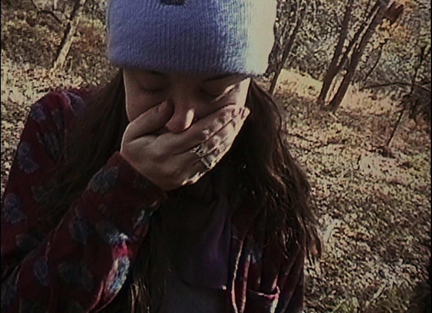 Heather Donahue covering her mouth with her hand.
