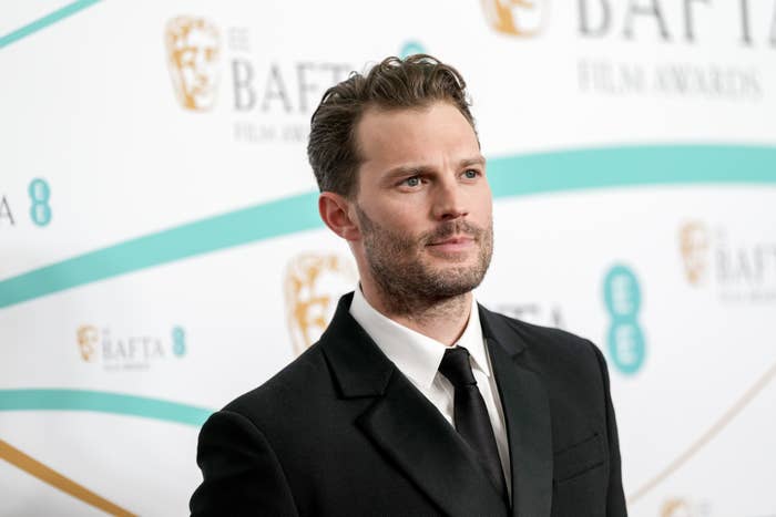 A closeup of Jamie in a suit at a media event