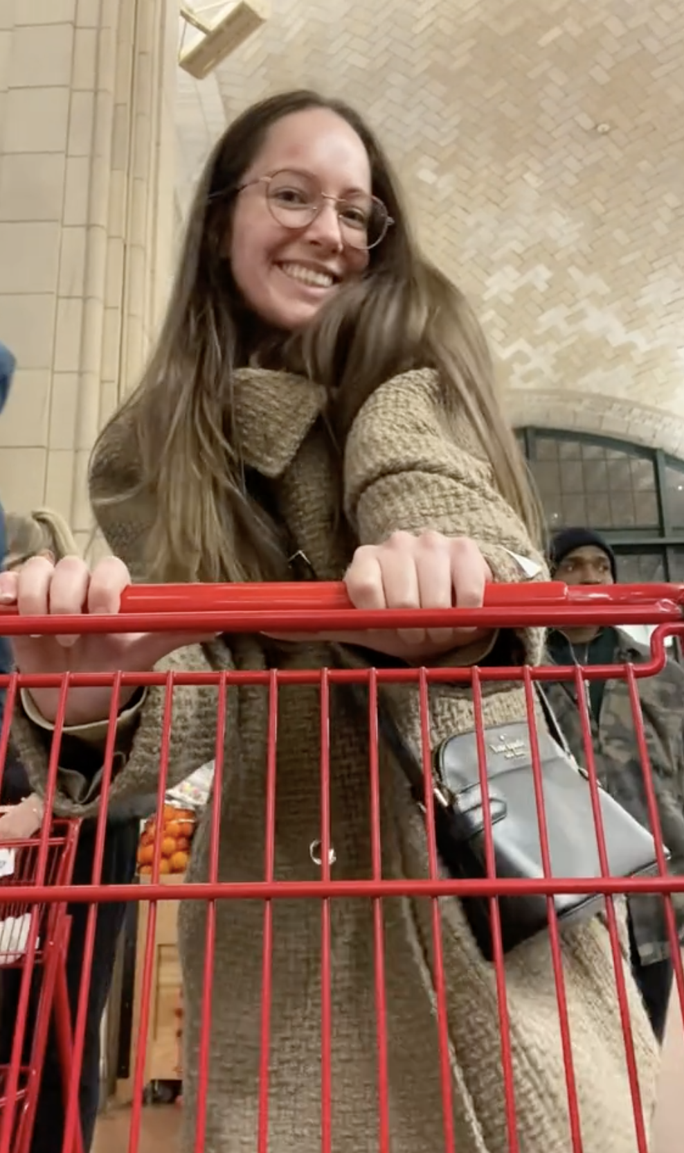 Maria pushing a shopping cart in a grocery store and smiling