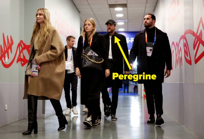 Arrow pointing to Peregrine Pearson as they walk down a hallway with several other people