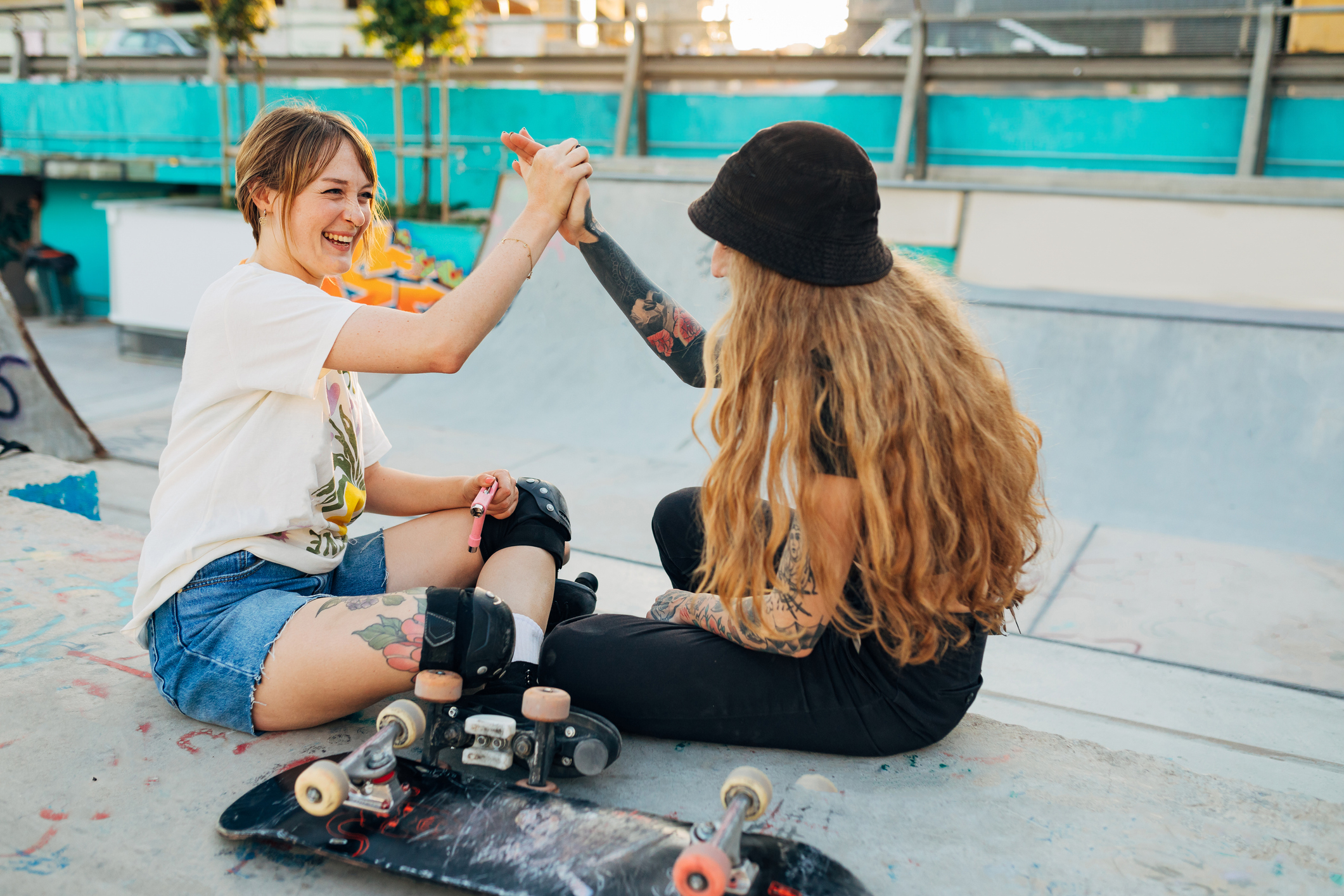 two friends at skatepark high fiving