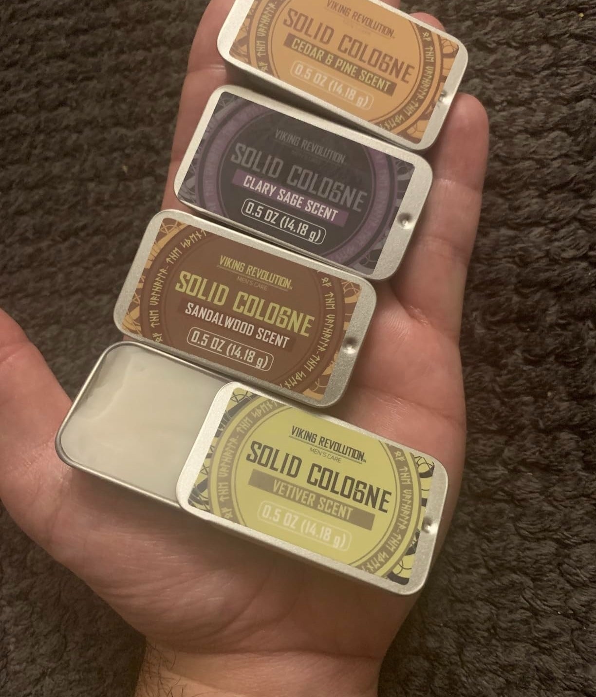 a reviewer photo of a hand holding all four scents