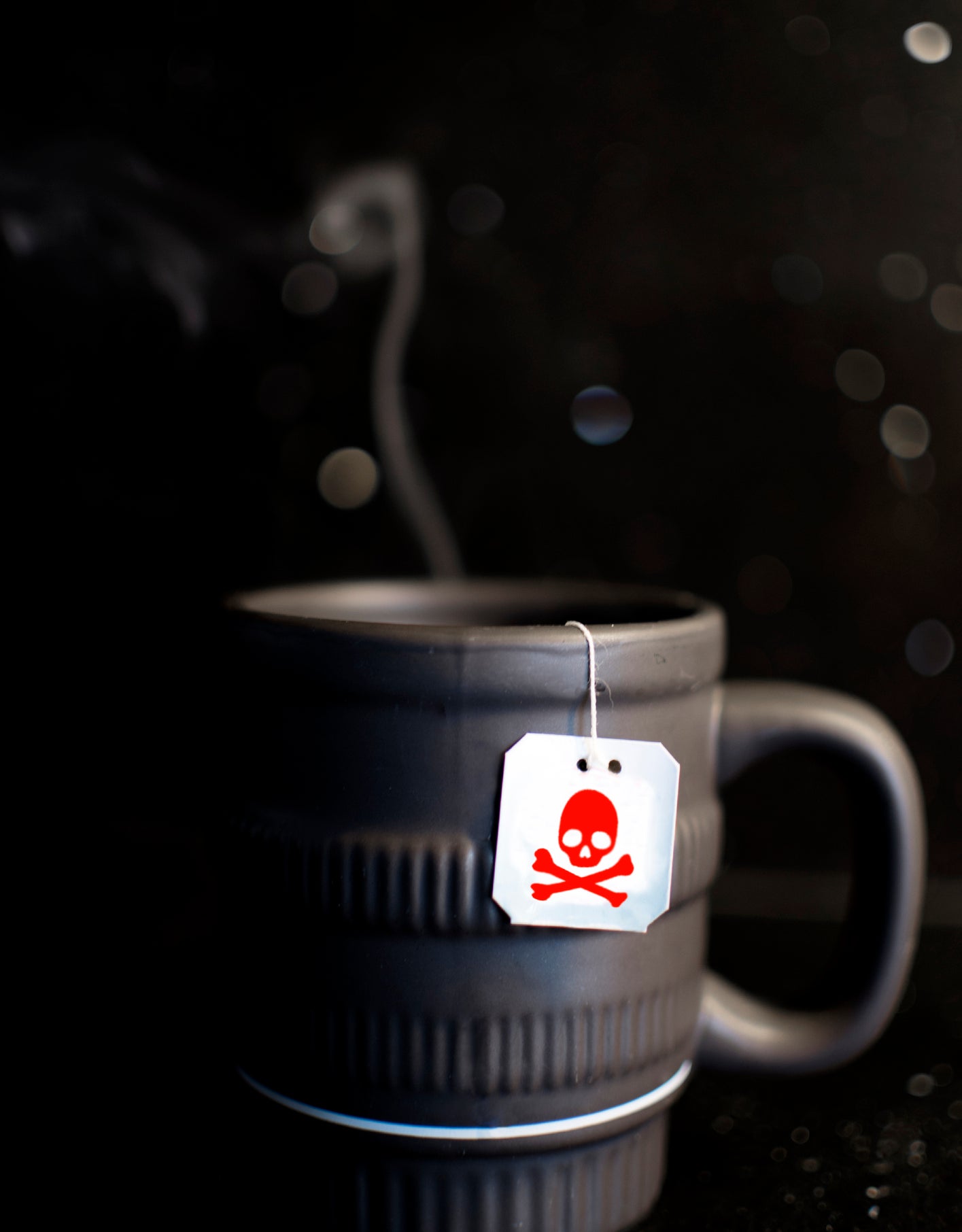 Close-up of a mug with a teabag with a skull and crossbones on it
