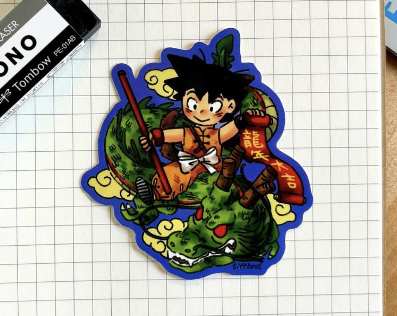 &quot;Goku-inspired sticker with Shenlong&quot; sitting on graph paper.