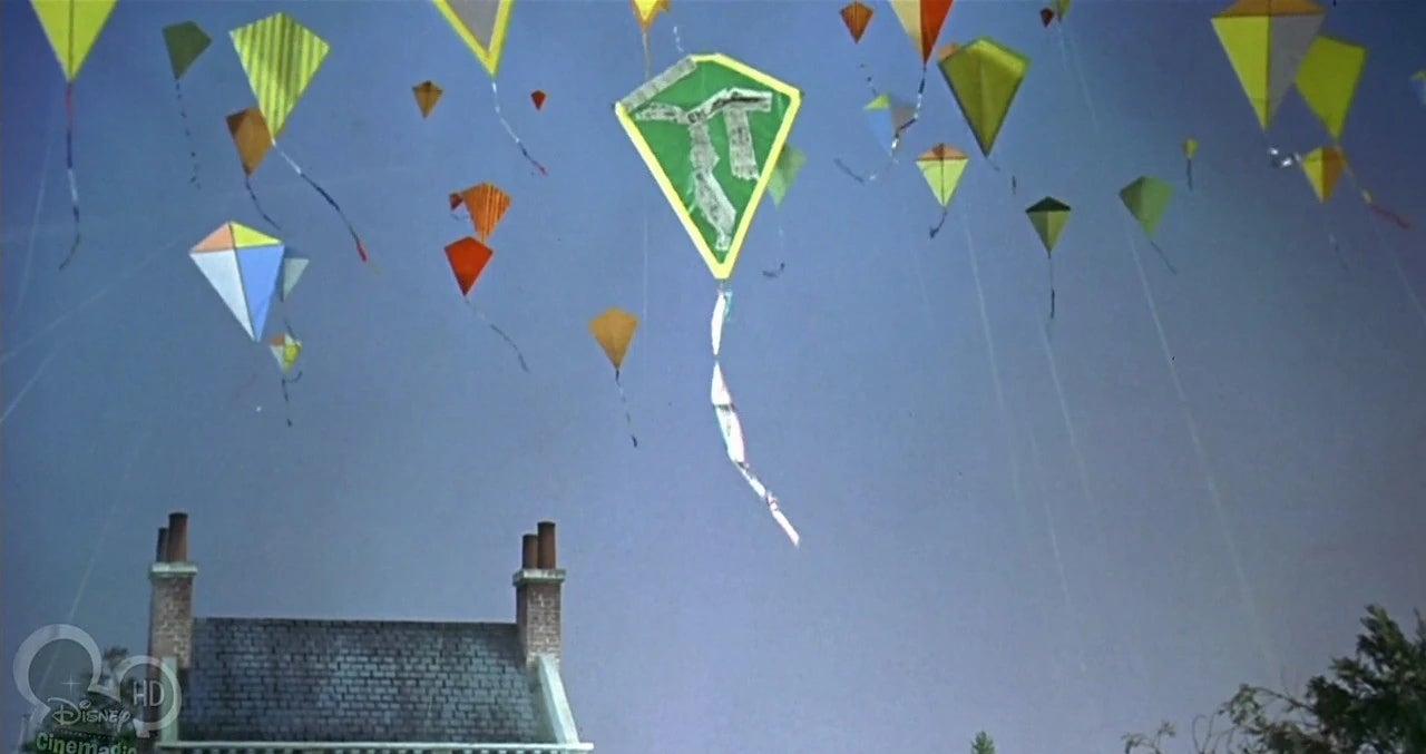 Kites fling in the sky above houses.