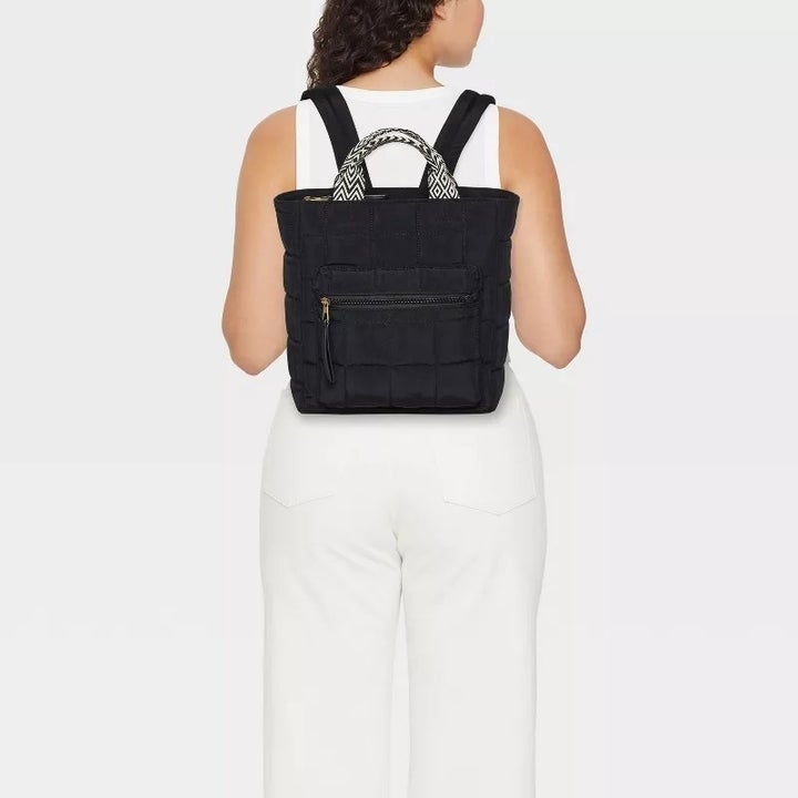 model wearing the black backpack