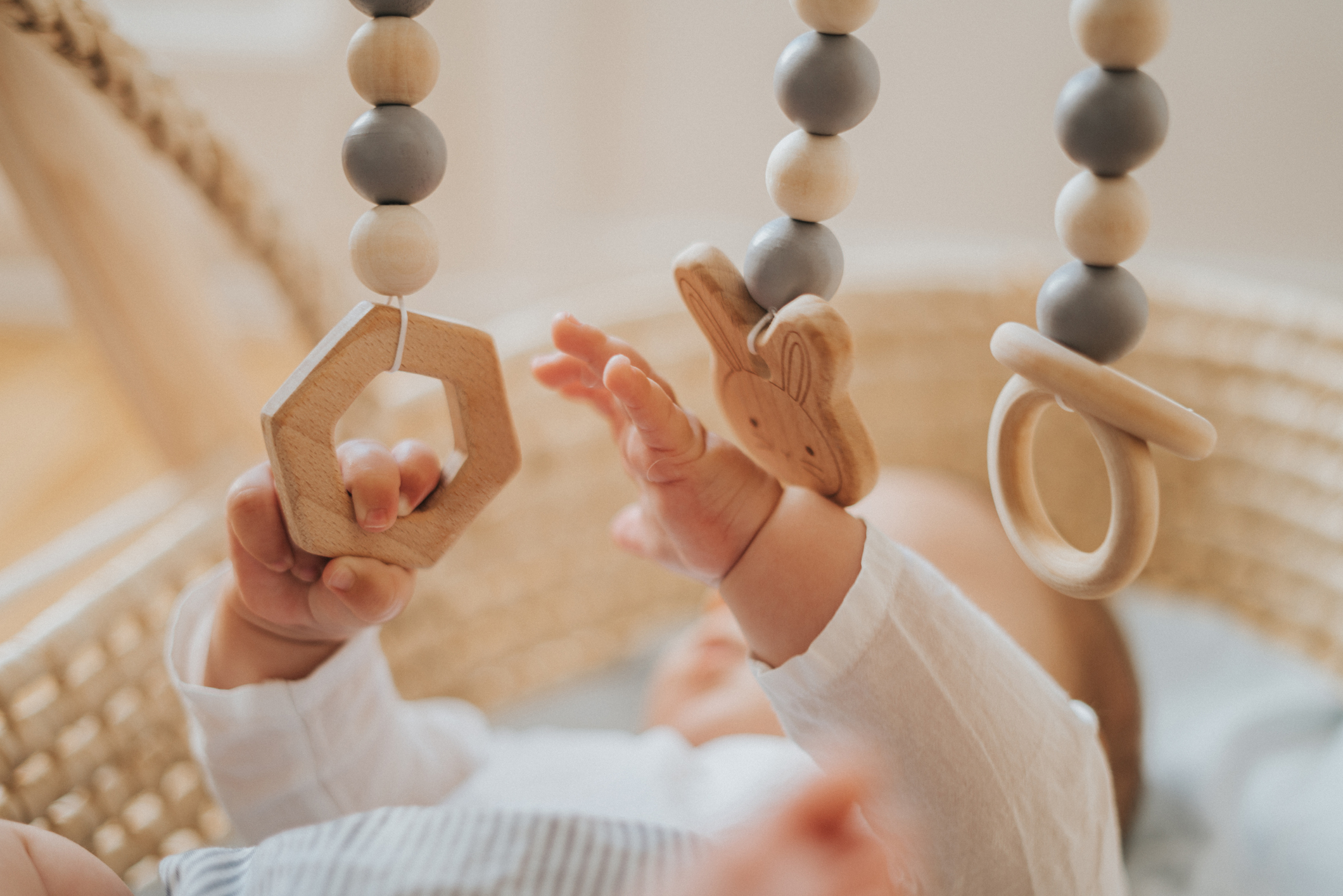 An infant playing with blocks above a crib