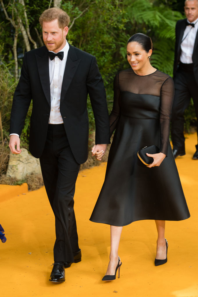 the two holding hands as they arrive to an event