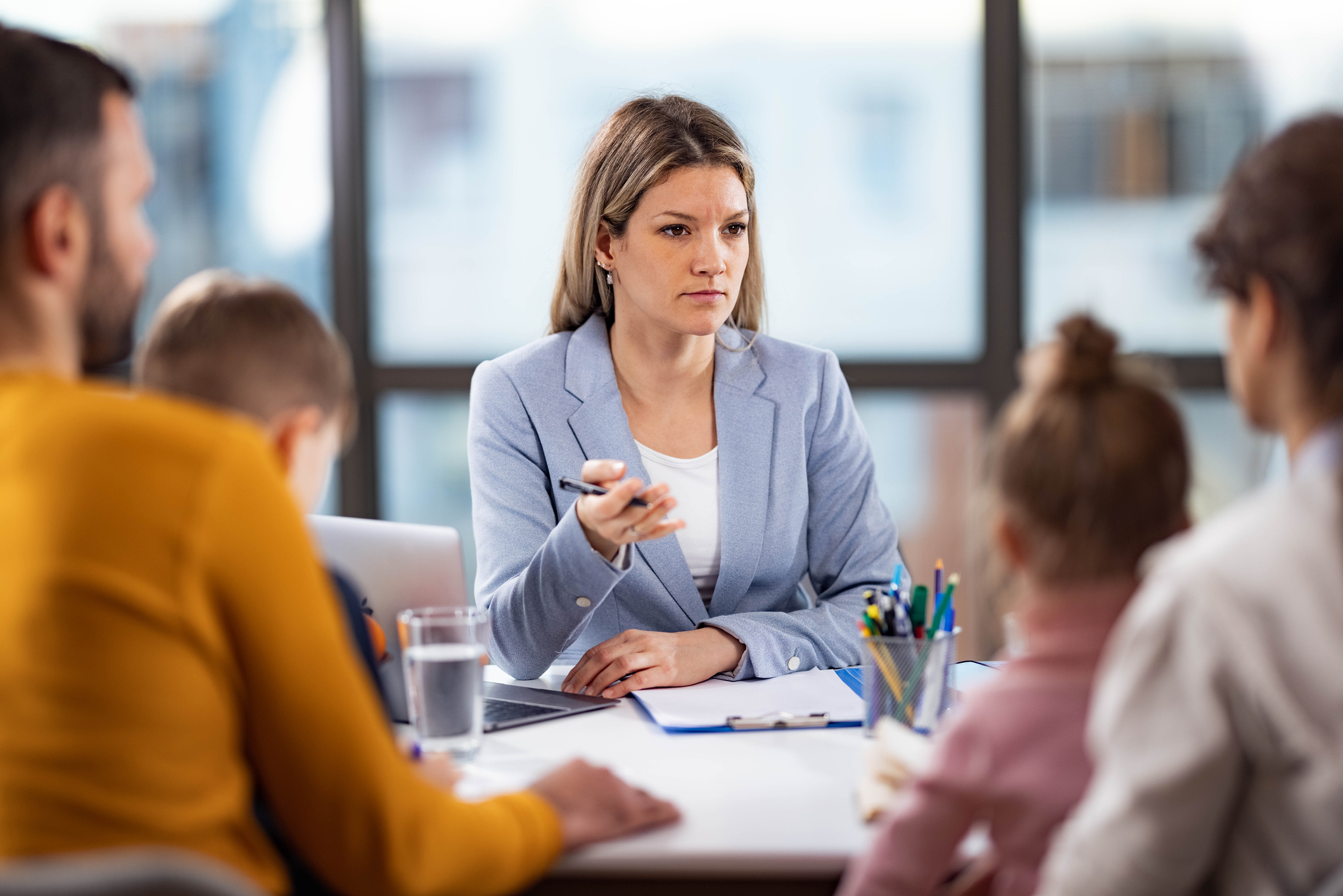 Female school principal talking to a family about children&#x27;s education in the office