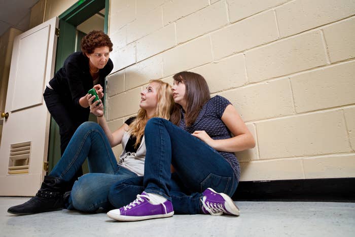 Teenage students disturbing a class with their cell phone use