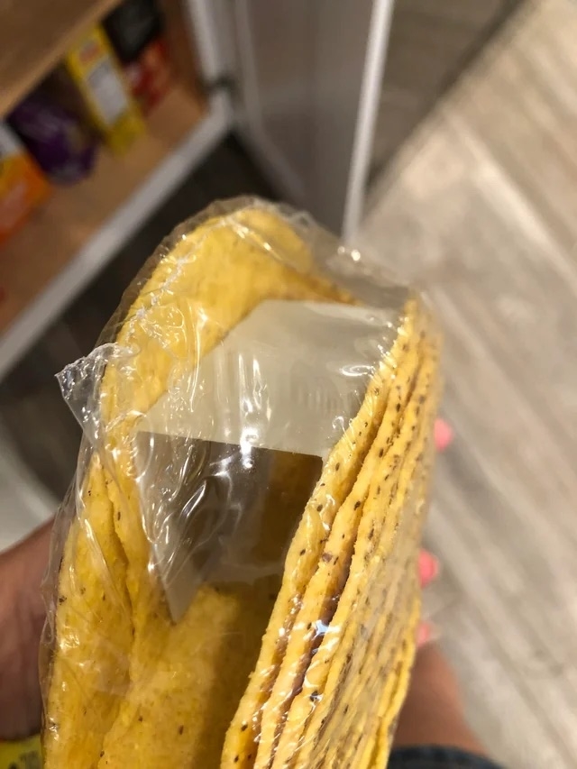 Someone holding a package of hard taco shells
