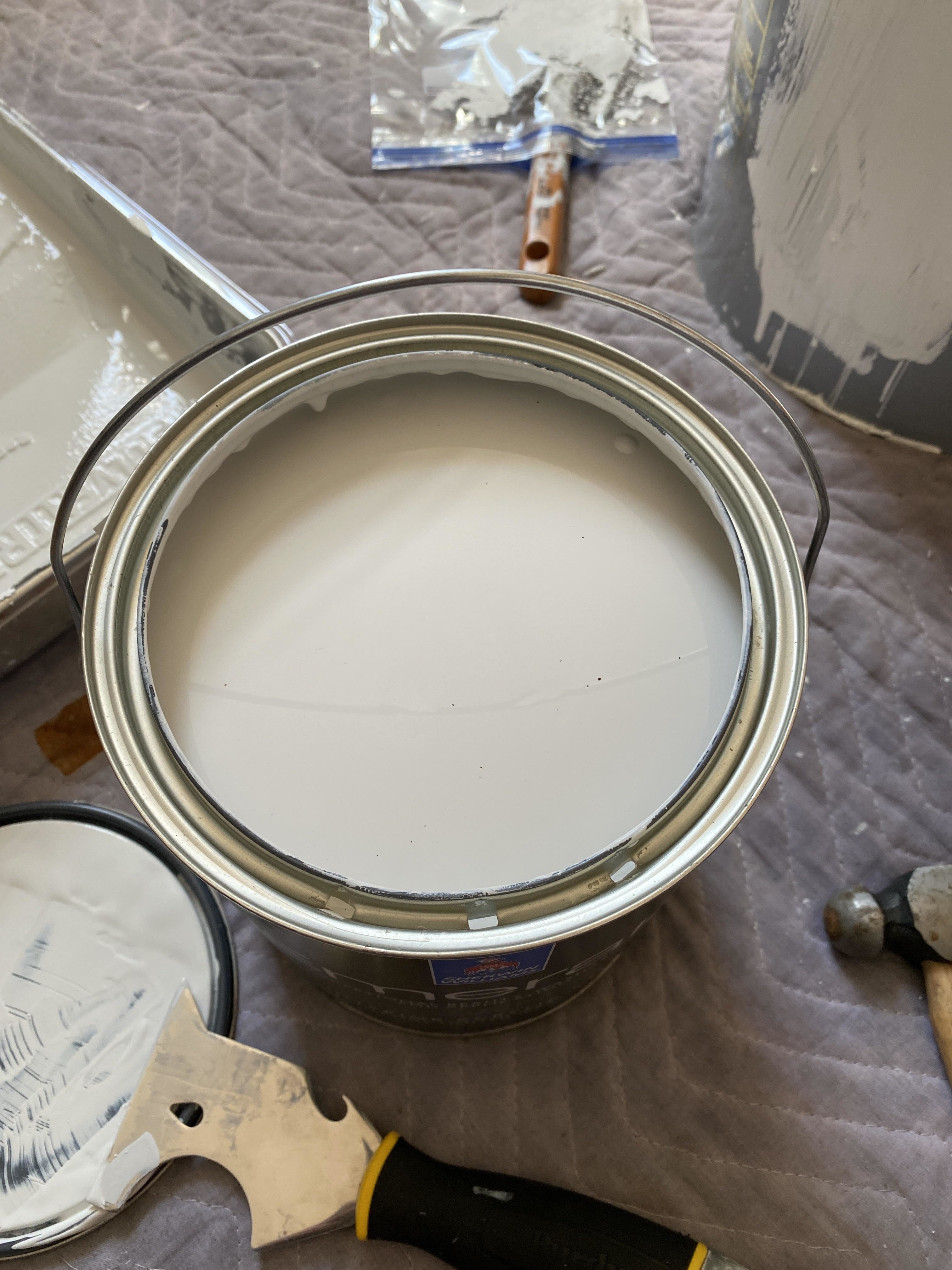 A top-down view of a paint can filled with white paint