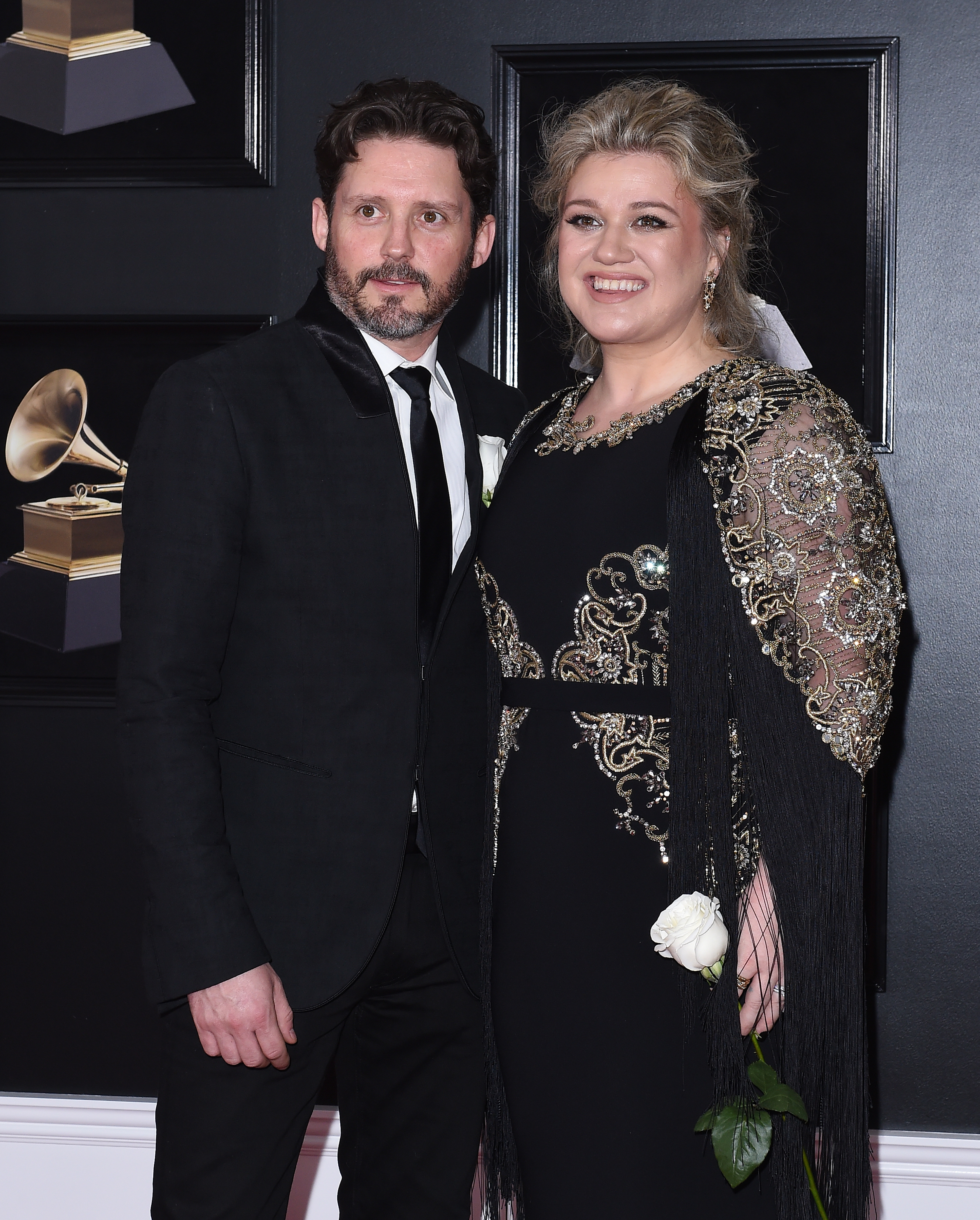 Close-up of Kelly holding a flower with Brandon at the Grammys