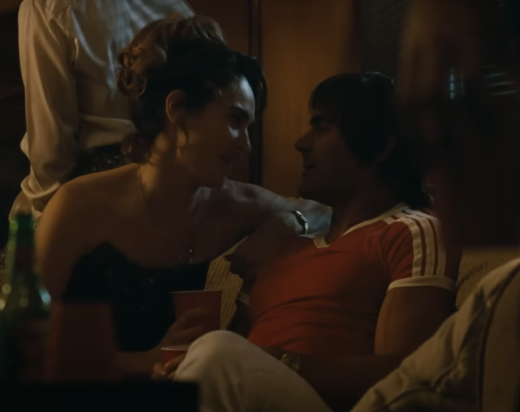 Zac with a woman in an intimate scene on a couch
