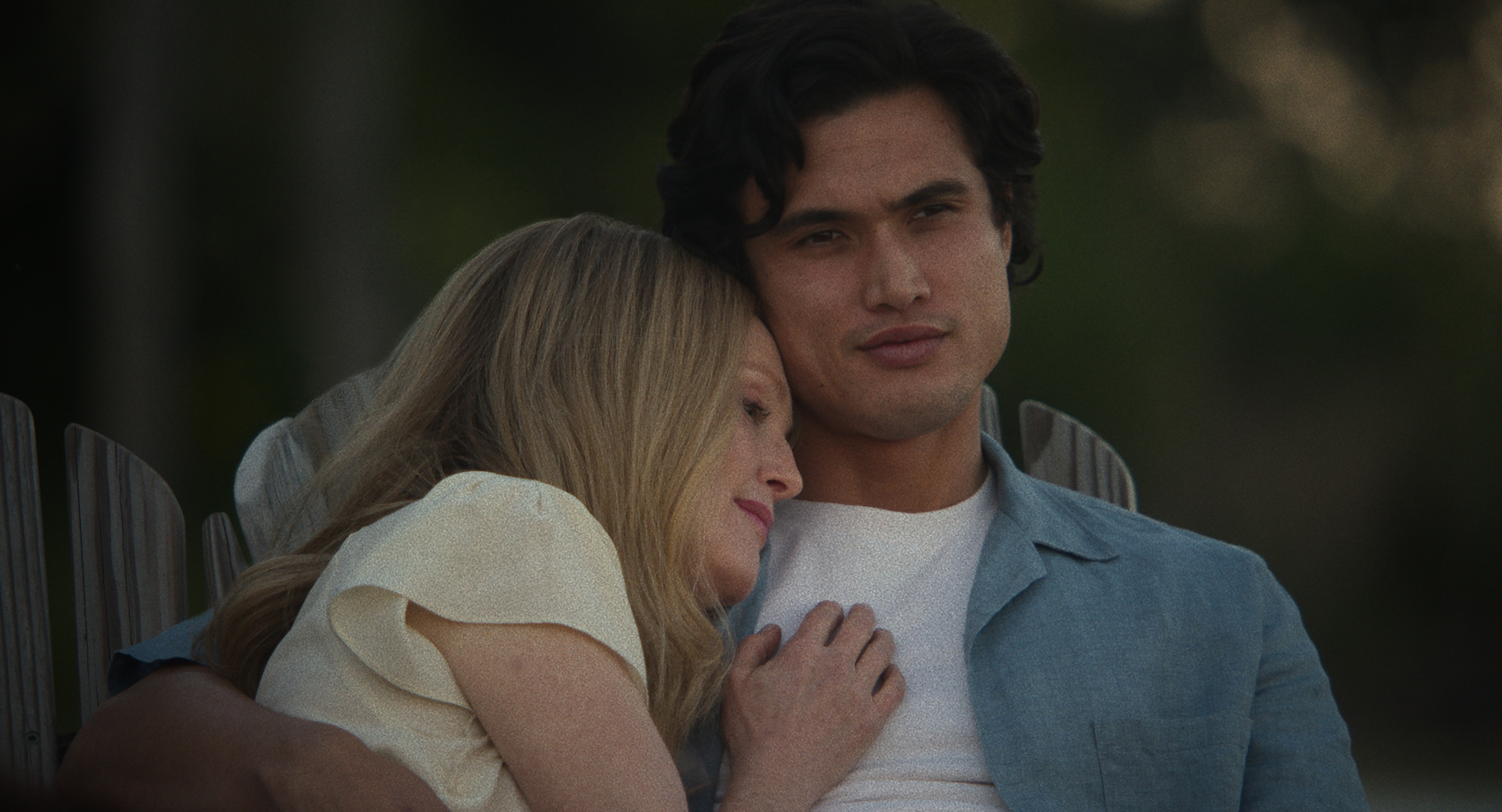 Julianne Moore and Charles Melton sitting with each other in a scene from &quot;May December&quot;