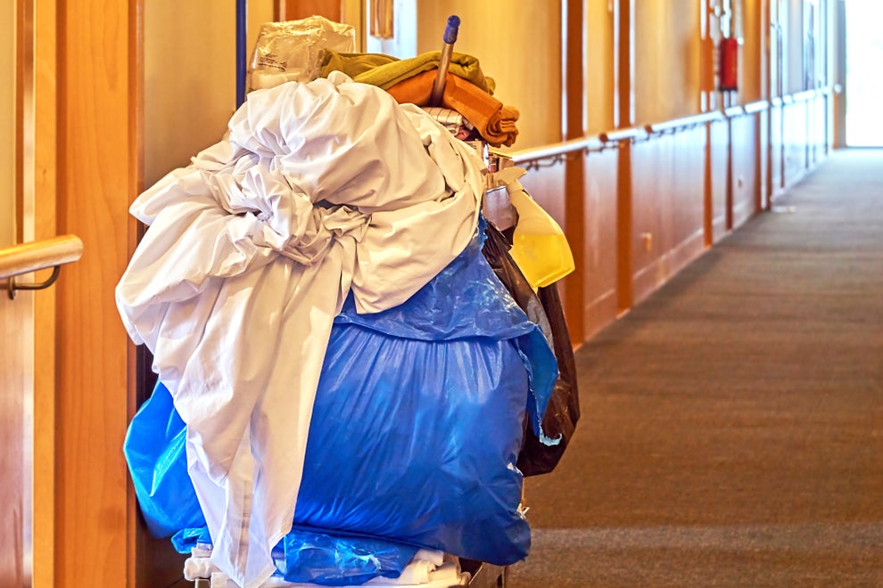 Cleaning trolley with a blue laundry bag in a corridor.