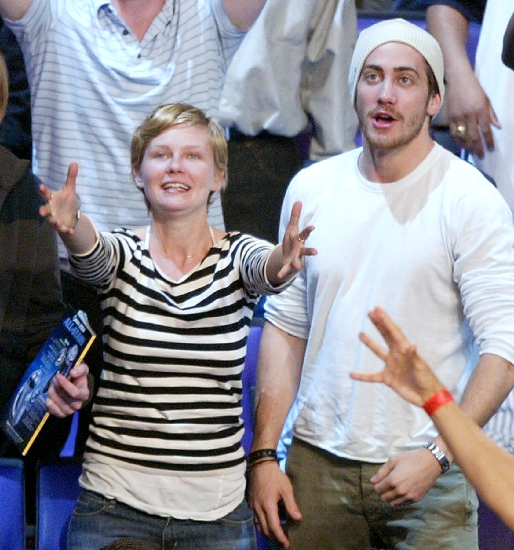 They're both wearing T-shirts and looking up; she's in jeans and he's in slacks