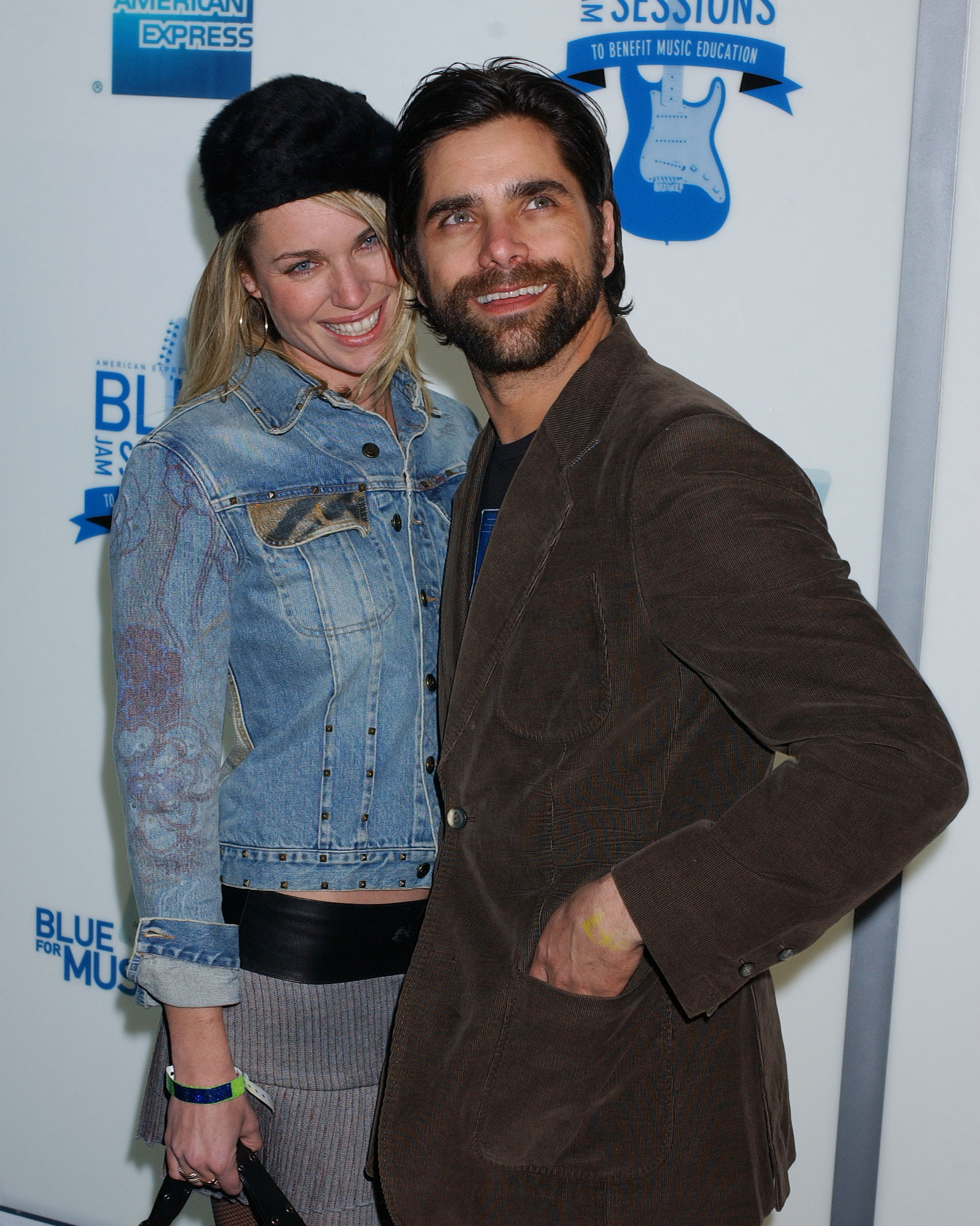 They&#x27;re both smiling at a media event; she&#x27;s wearing a hat and denim jacket, and he&#x27;s wearing a short coat