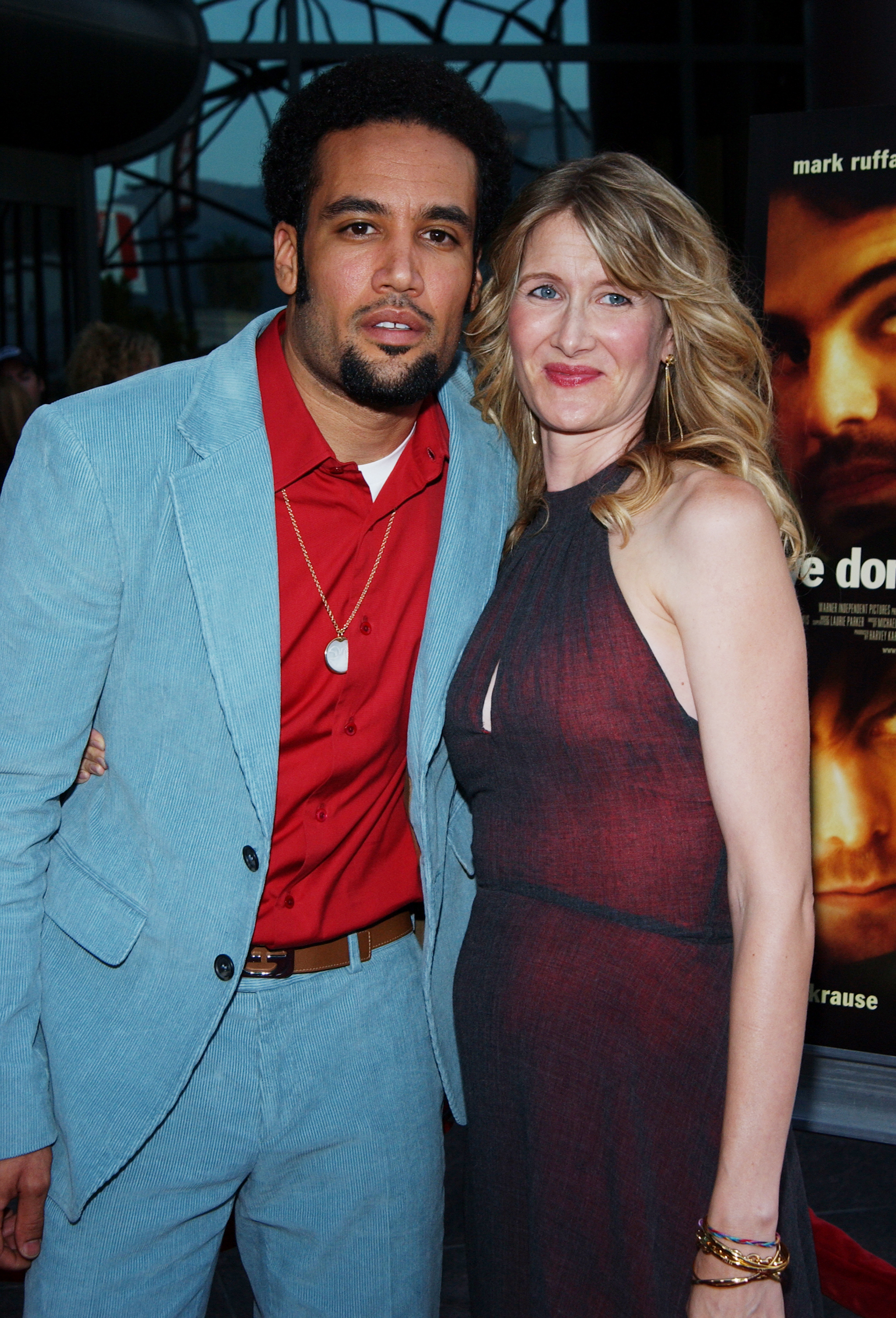 He's wearing a shirt and suit, and she's wearing a halter-top dress