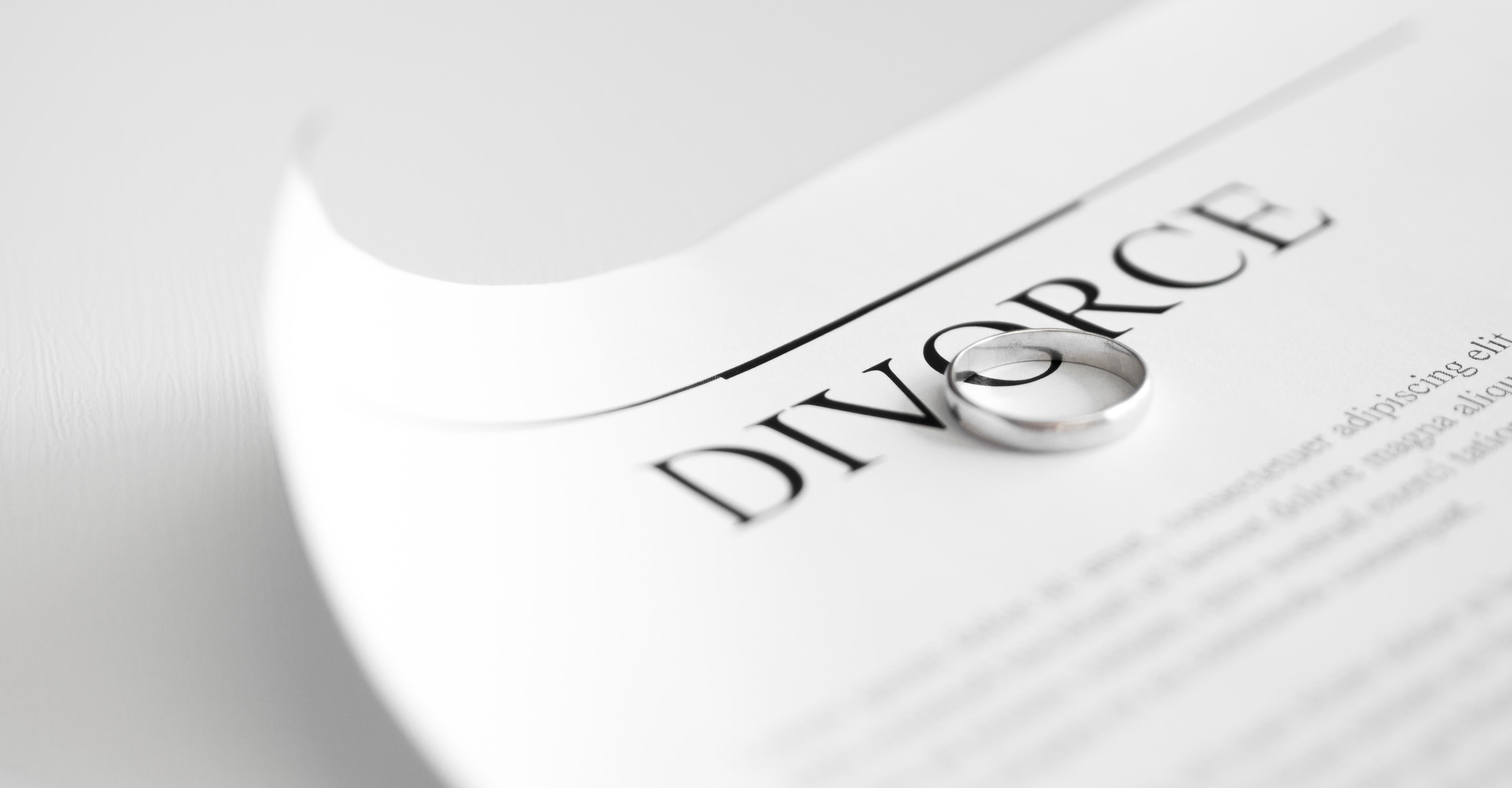 Divorce papers with a wedding band sitting on top of them