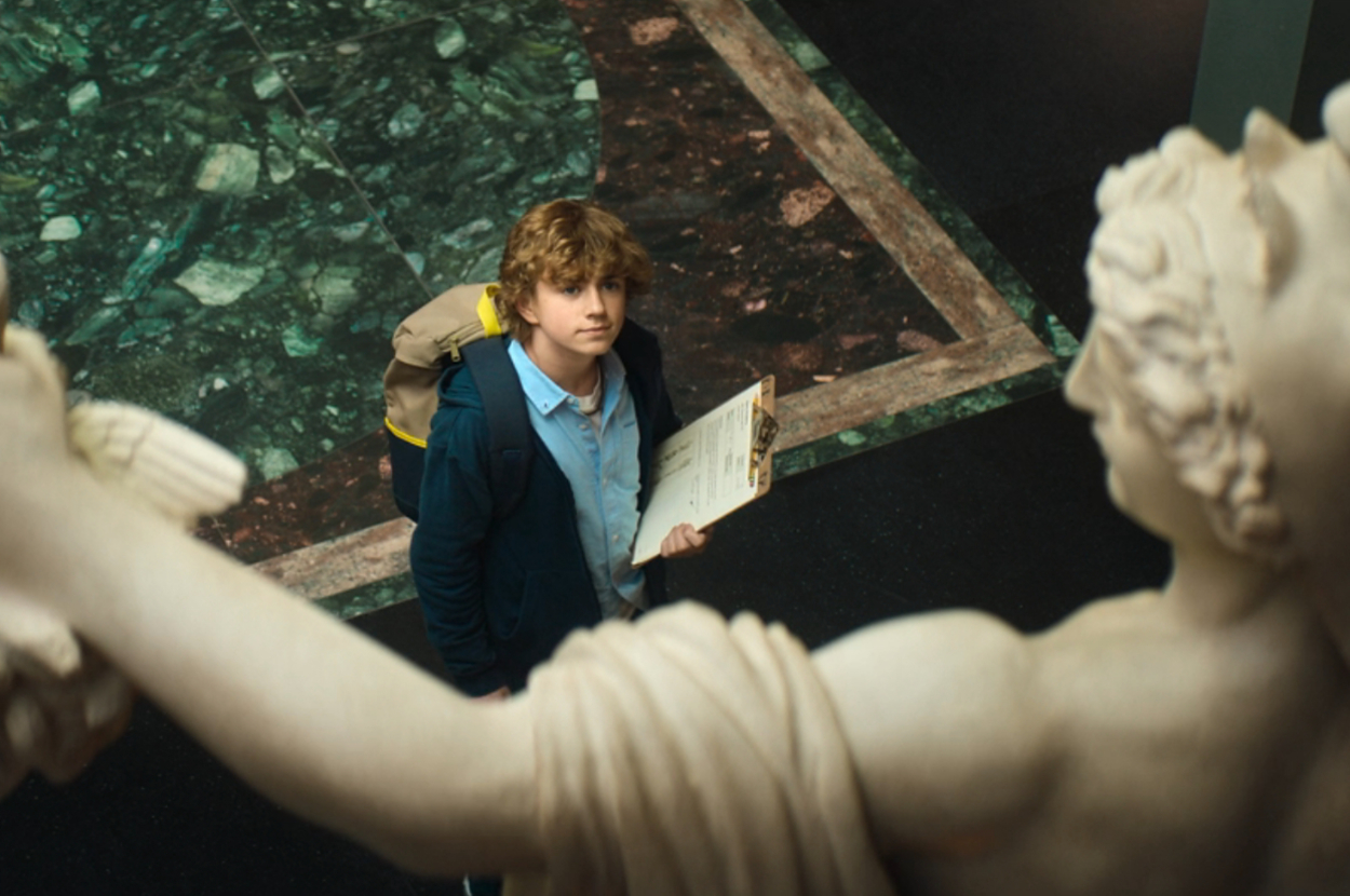 Walker Scobell looking up at a statue at the Met as Percy in Percy Jackson and the Olympians