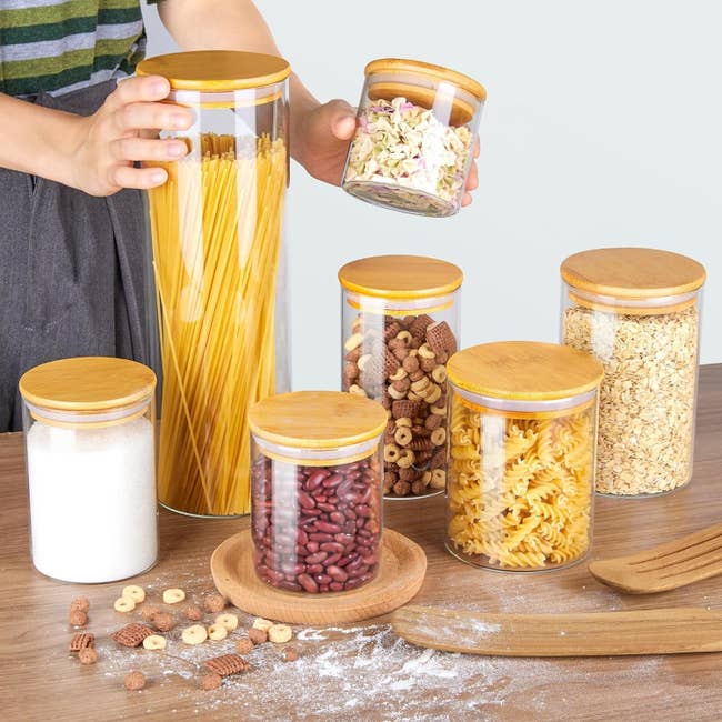 the seven glass jars in different sizes with bamboo lids