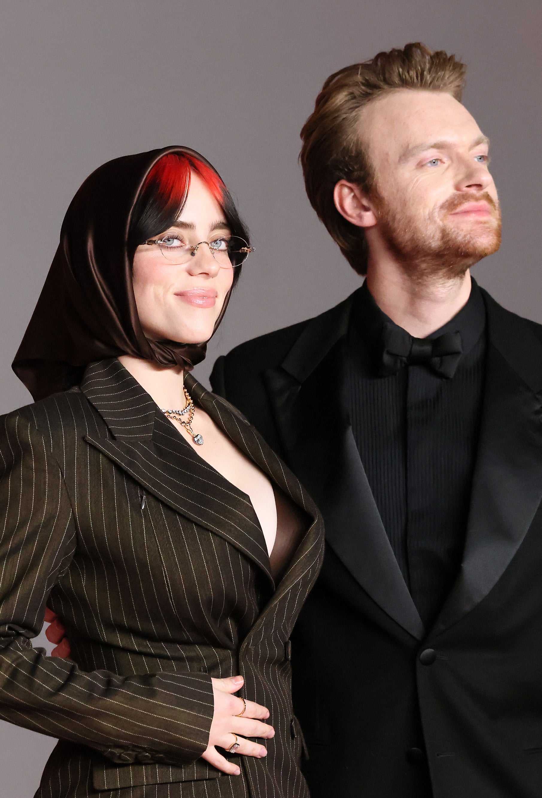 Close-up of Billie and Finneas smiling in suit jackets