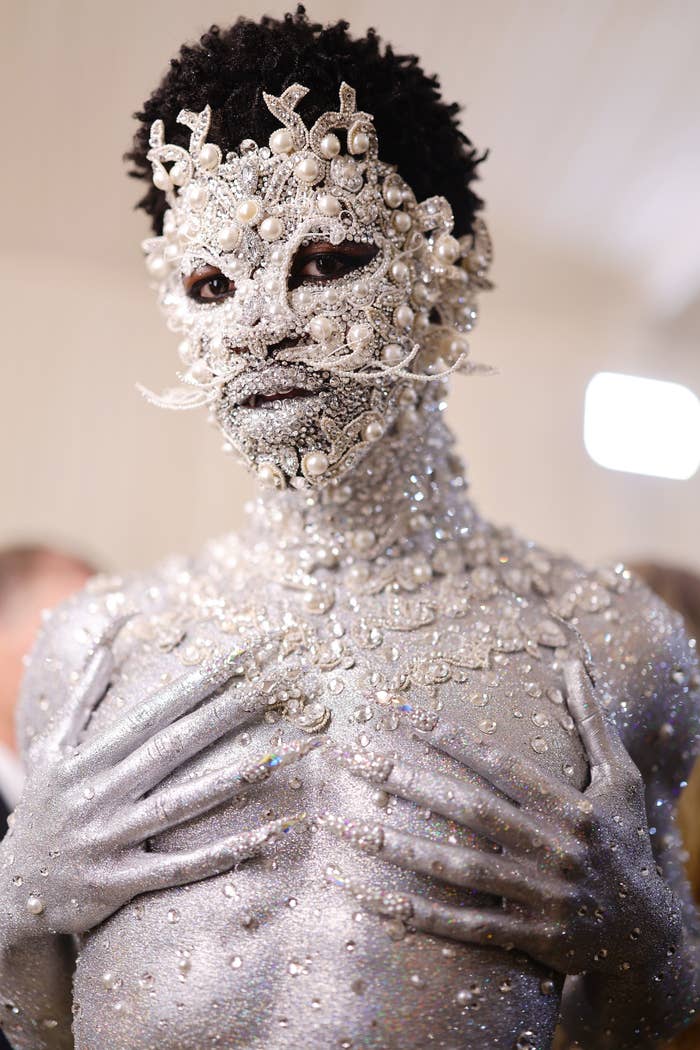 Close-up of Lil Nas X wearing jewel-encrusted silver body and face paint