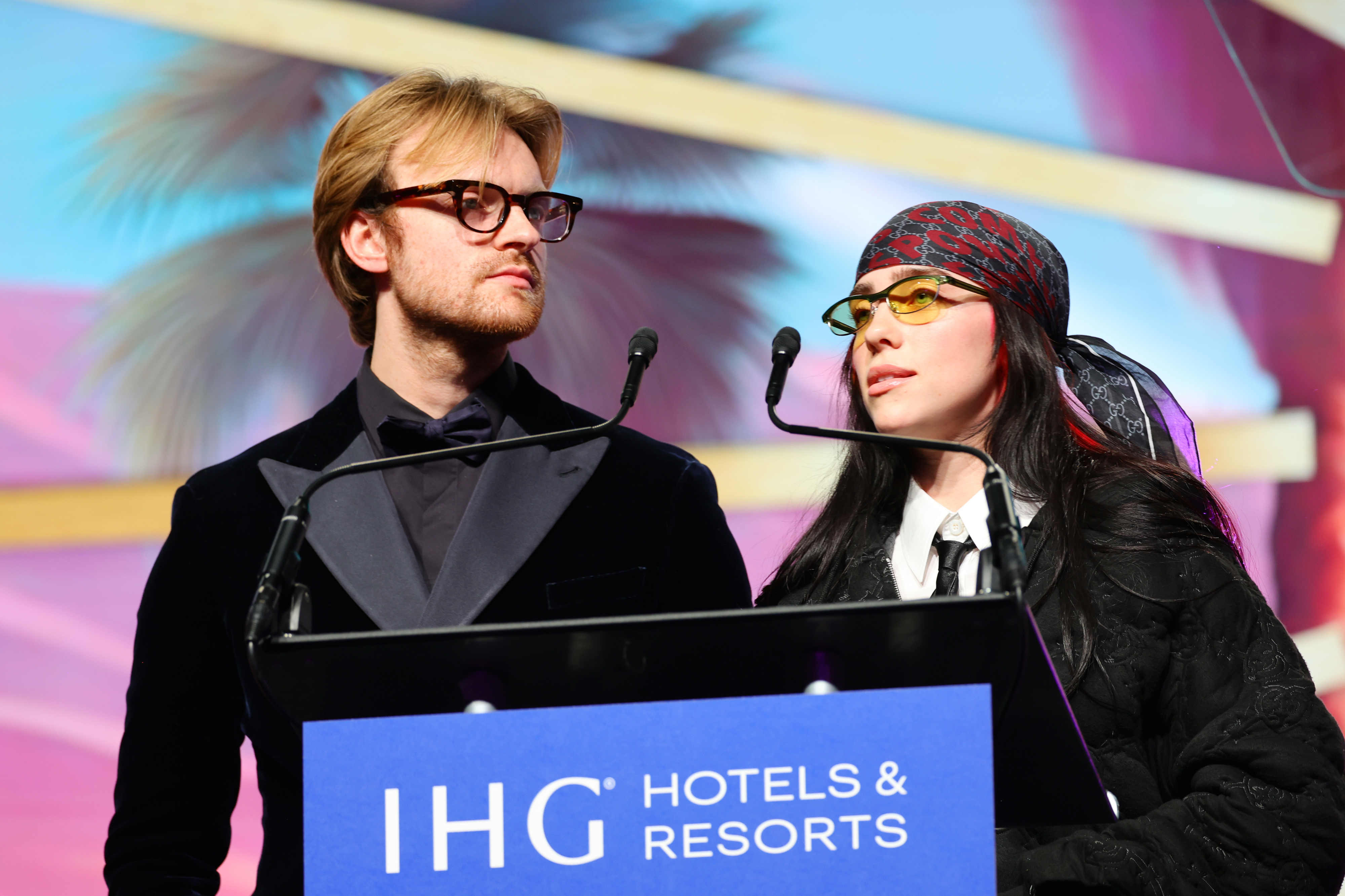 Finneas and Billie onstage at a podium