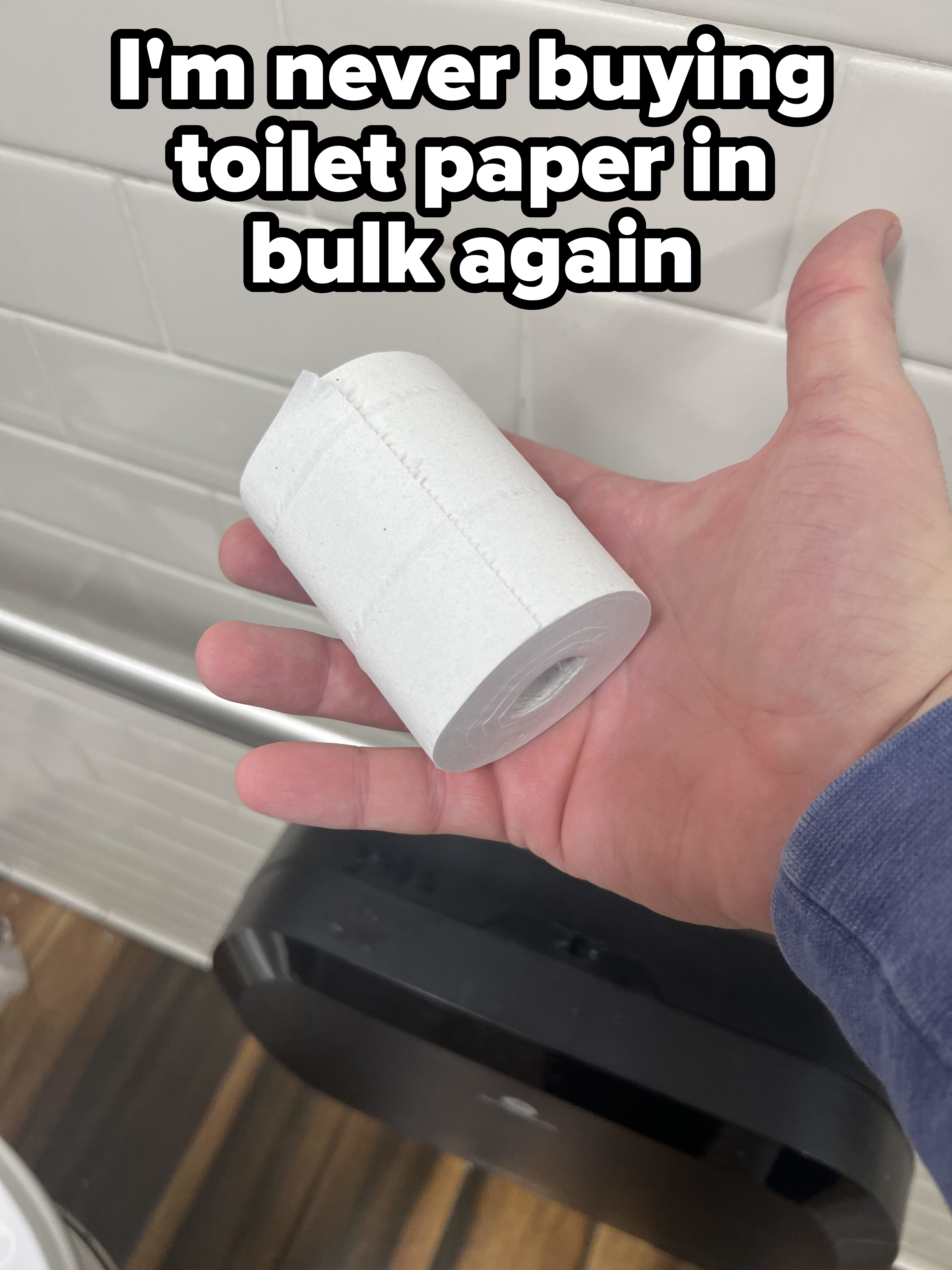 A person holding a very small roll of toilet paper