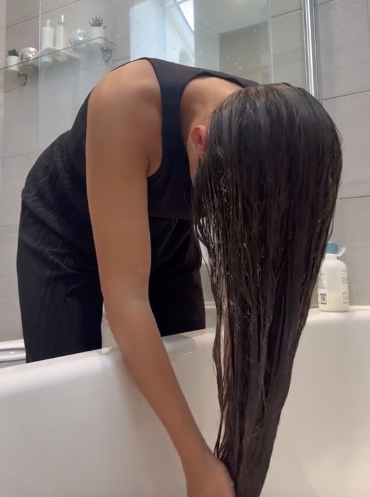 person putting a mask on their hair in the tub