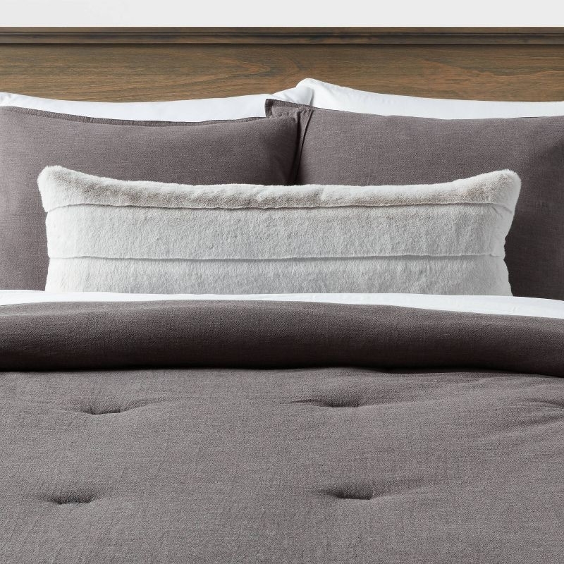 the pillow in light grey on a bed