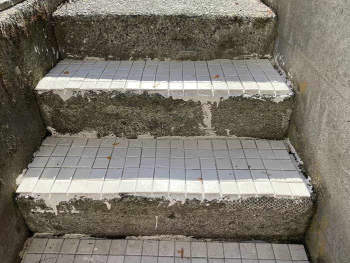 An outdoor staircase is unevenly tiled