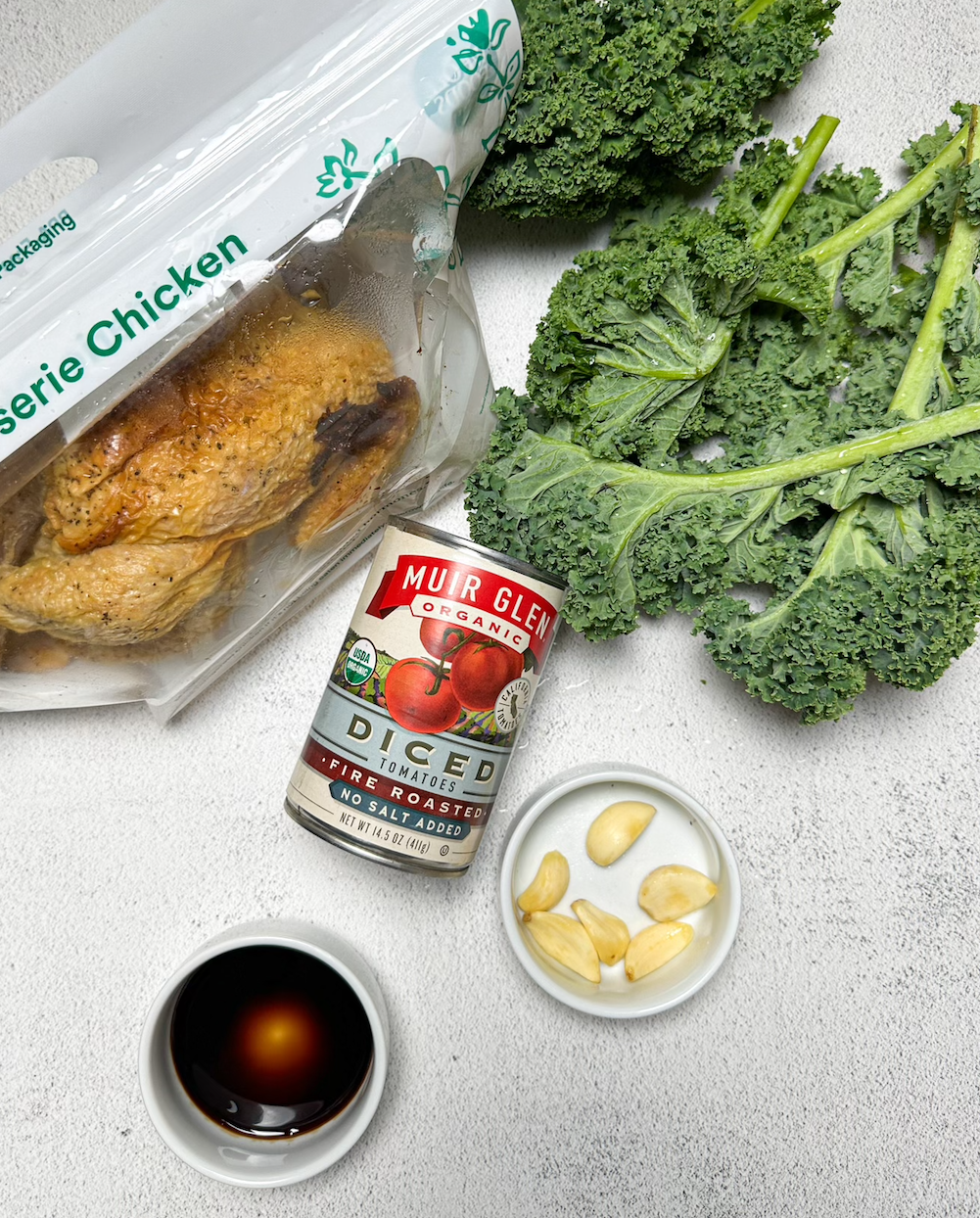 Ingredients: rotisserie chicken, a can of diced tomatoes, garlic cloves, fresh kale, and balsamic vinegar
