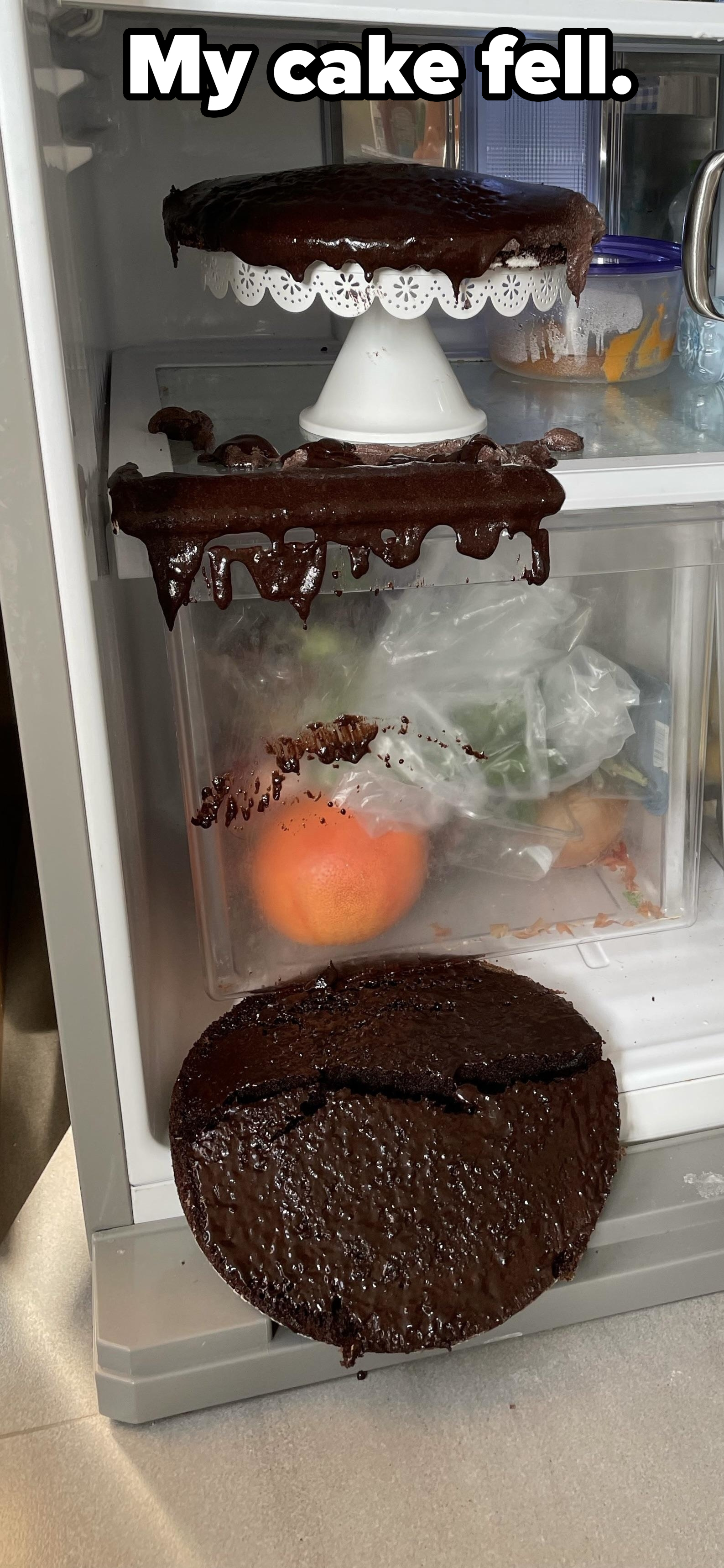 A cake that fell off a cake stand in the refrigerator