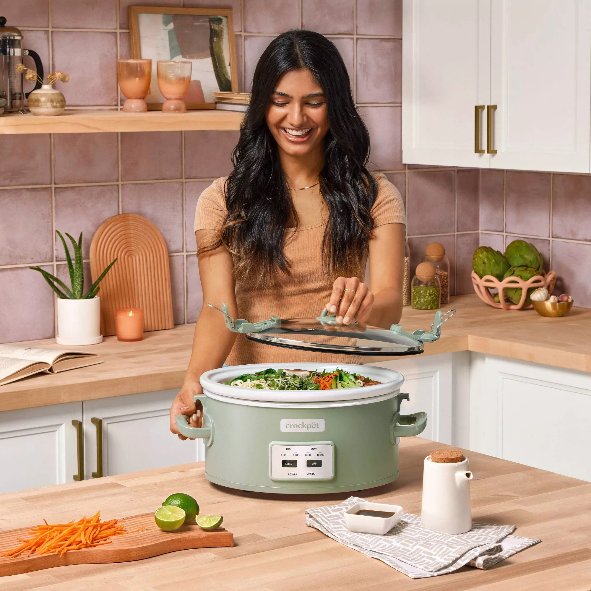 A model lifting the lid off the pot which has a digital panel