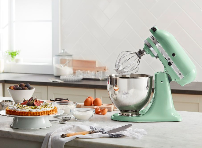 Green KitchenAid stand mixer on kitchen counter with pie