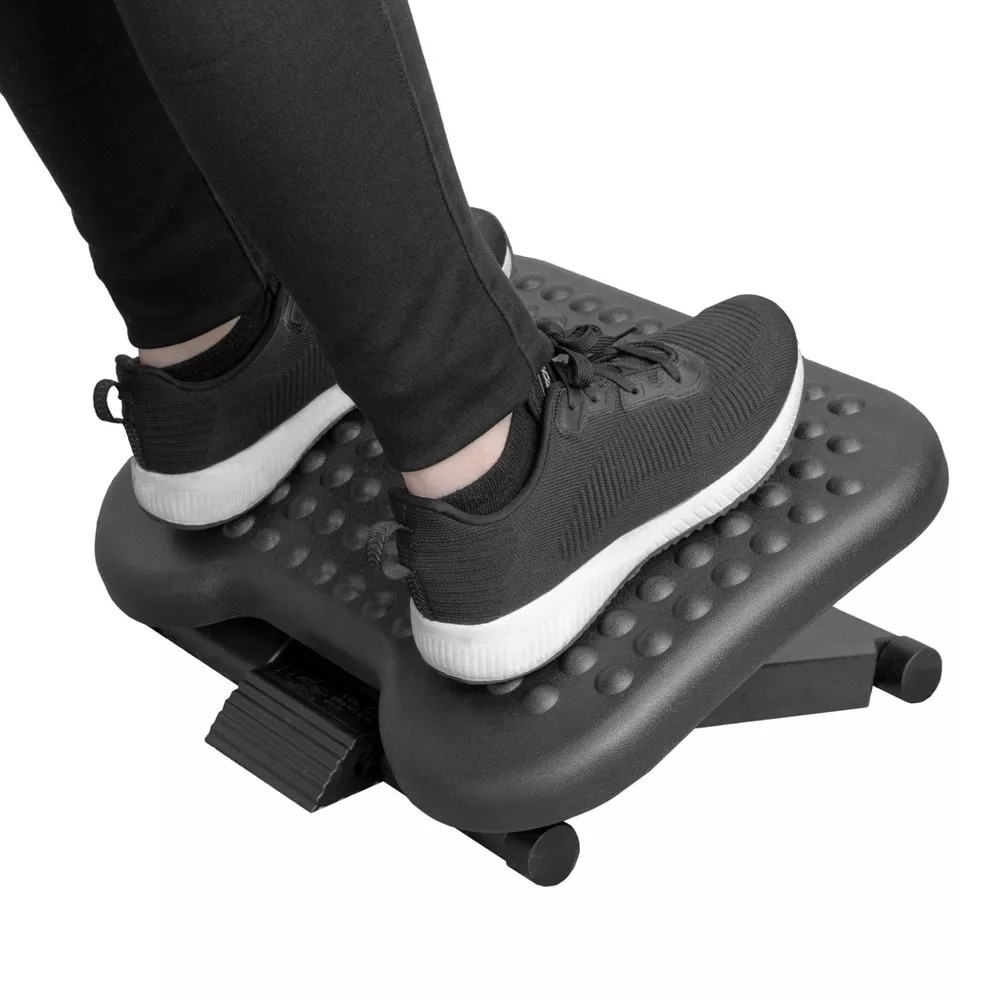 the black ergonomic foot rest with feet on it