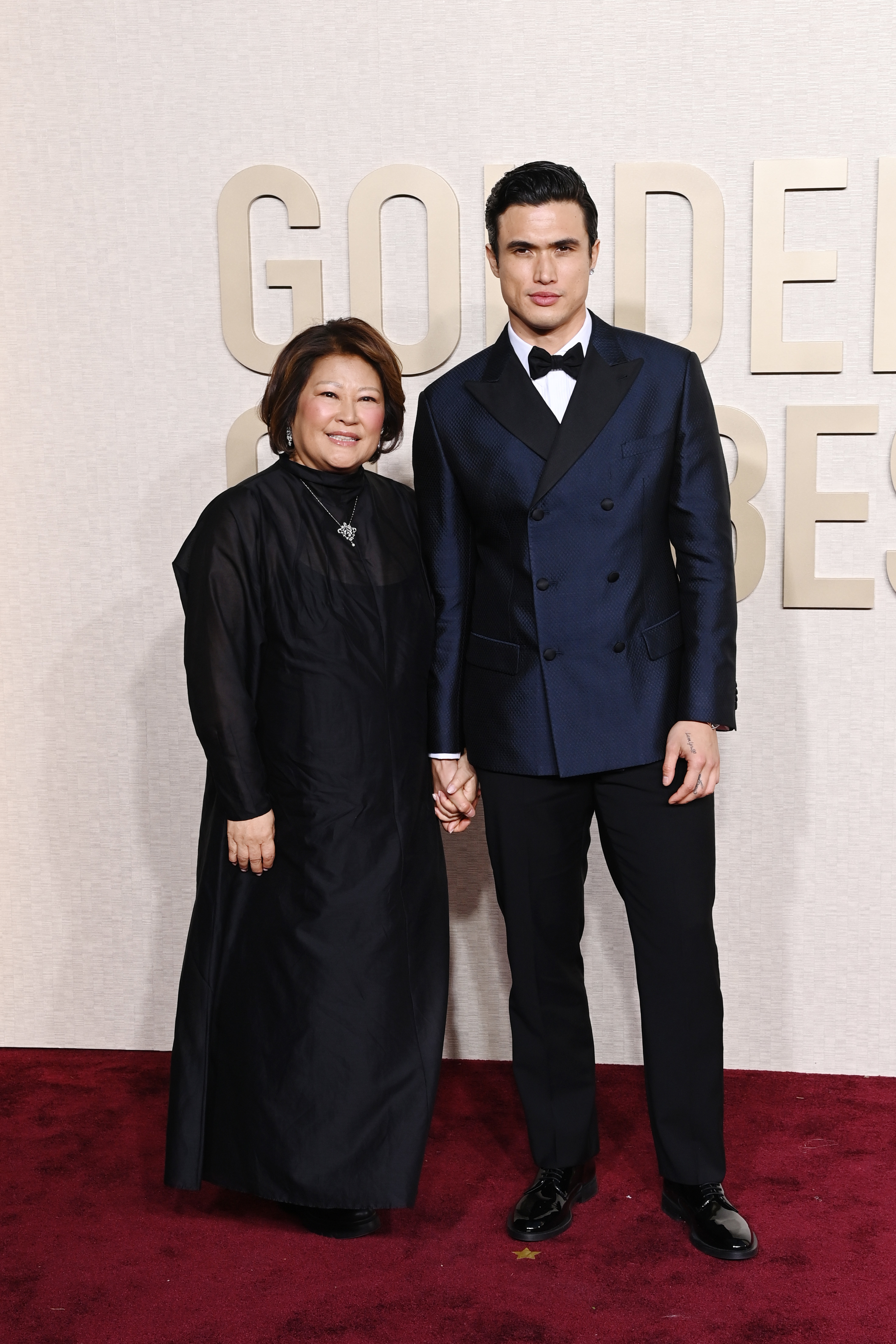 Sukyong and Charles Melton holding hands on the red carpet