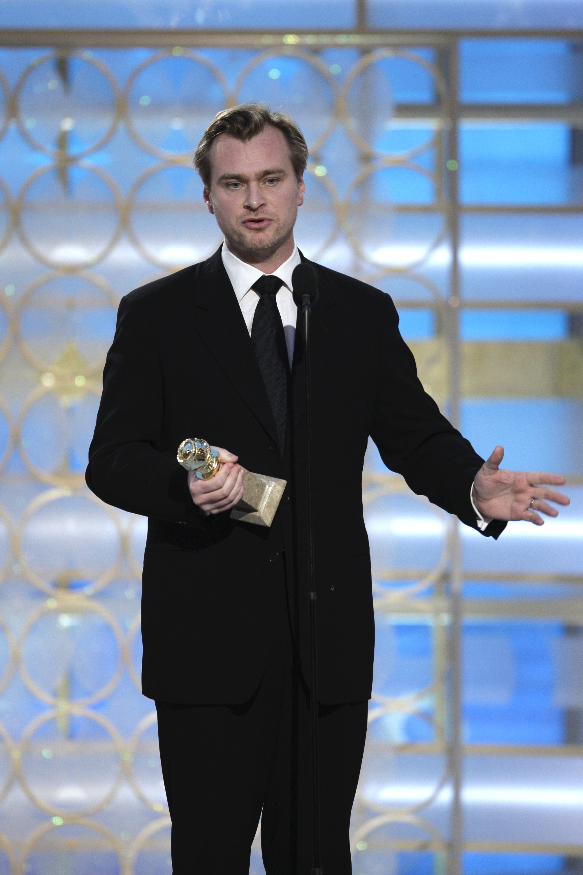 Christopher Nolan holding a Golden Globe award